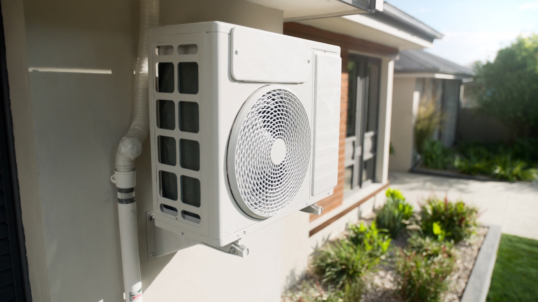 Outdoor air conditioning unit installed beside a new brick home