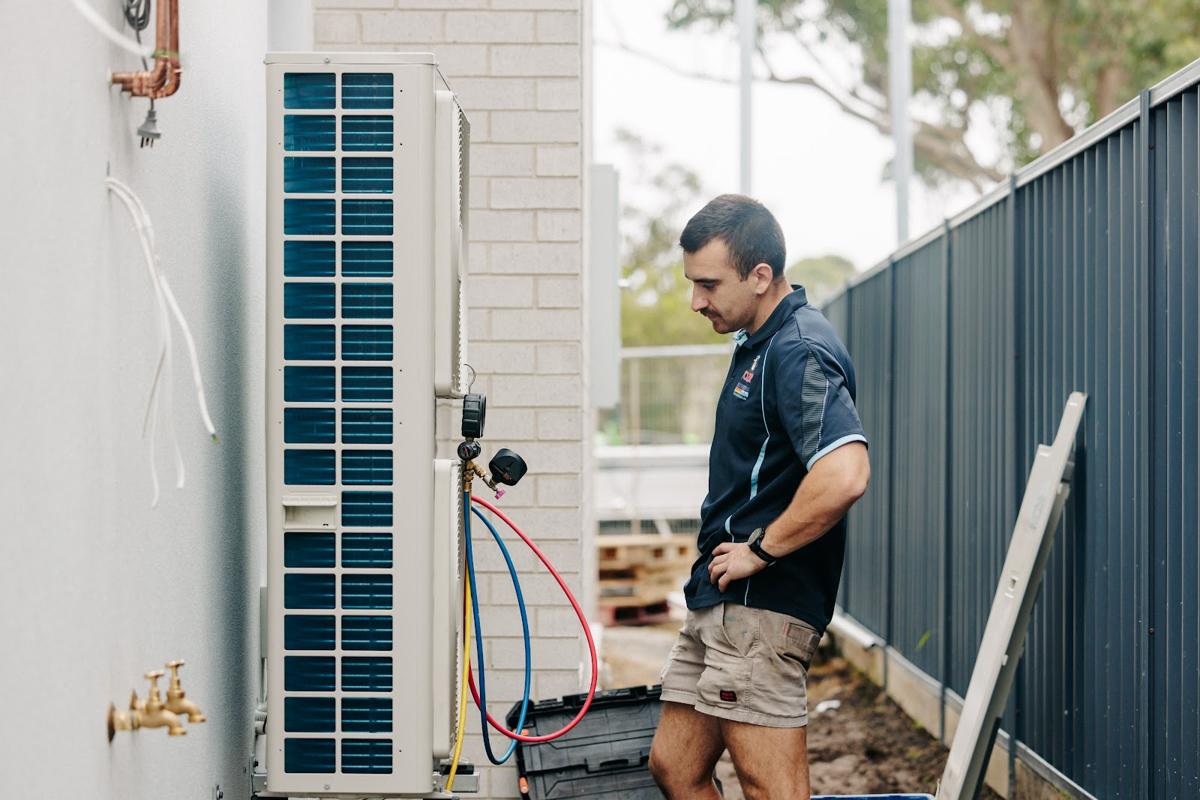 Technician commissioning a new outdoor unit at a home