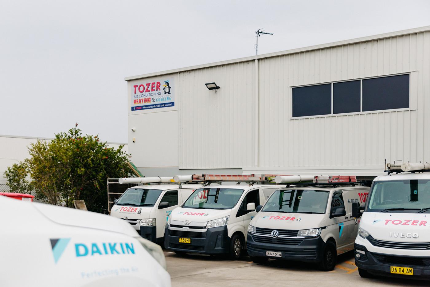 The TOZER warehouse and showroom at Beresfield, with the vans out the front